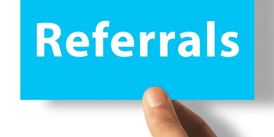 Holding blue paper with referrals note.